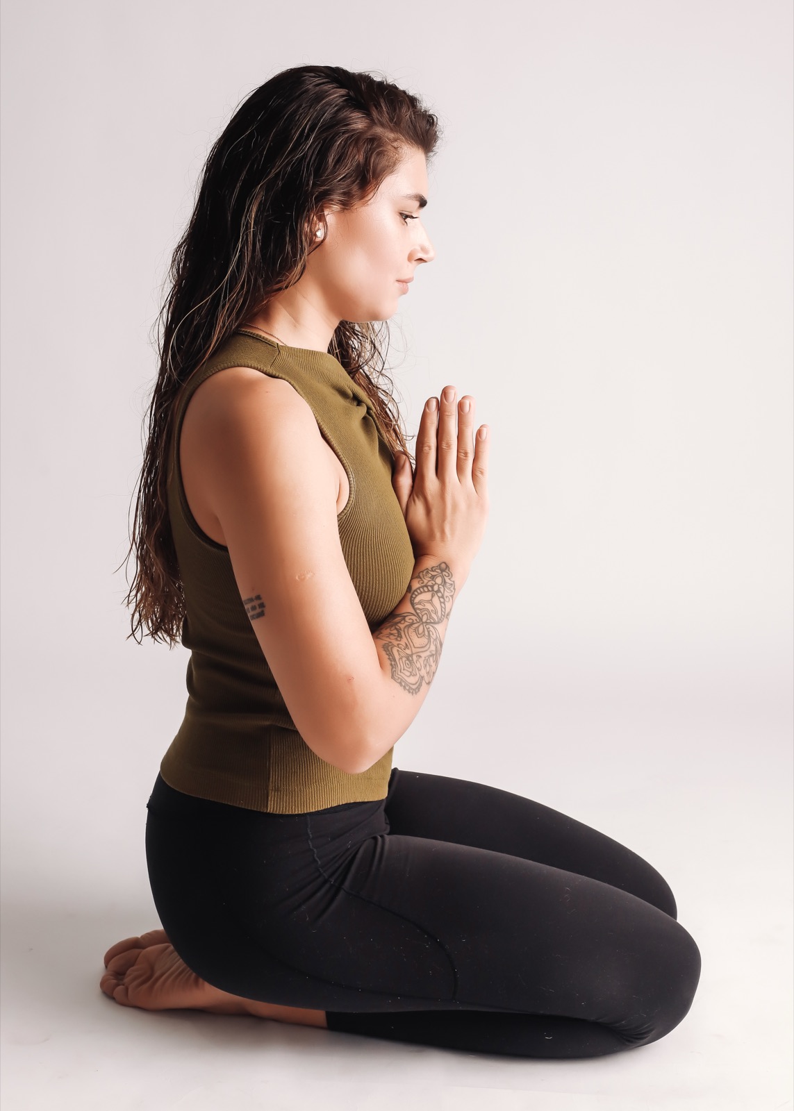 Brenda ajoelhada, mãos em prece, em meditação